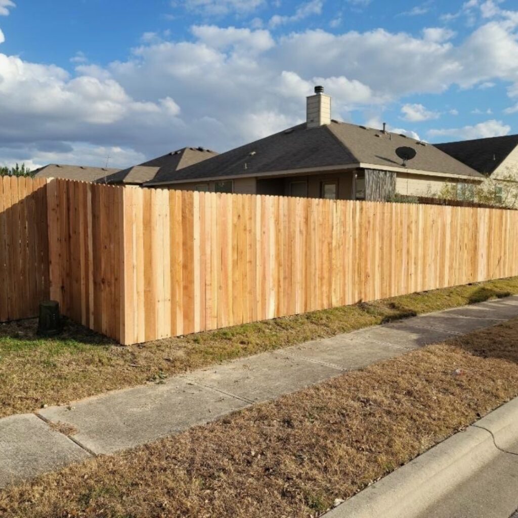 Custom vertical picket fence featuring evenly spaced slats for security and style.