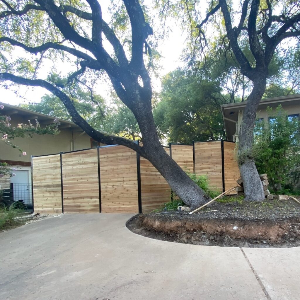 Horizontal plank fence surrounding a backyard in Austin, TX — stylish and secure.