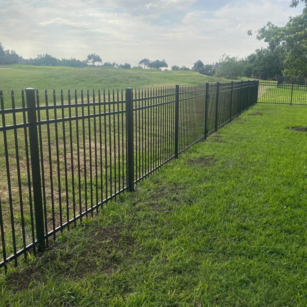 Elegant wrought iron ornamental fence enhancing the entrance of a residential property.