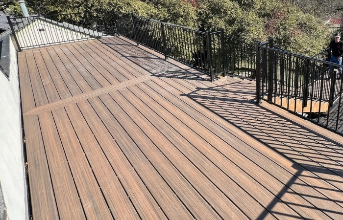 Rooftop deck with Toasted Sand composite decking, spiral staircase, custom Trex bar, and ornamental iron railing