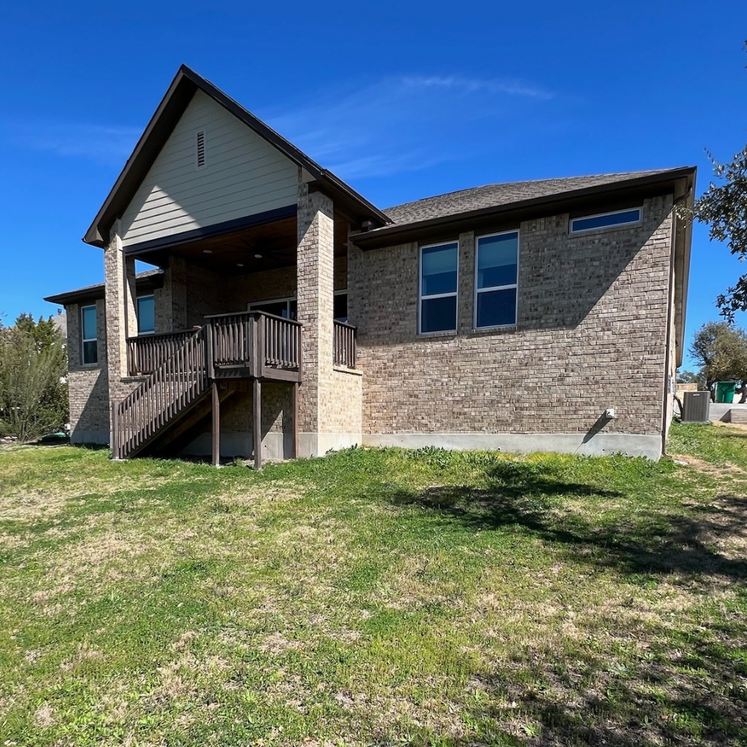 Exterior view of home with empty yard before adding deck, cover, and lighting