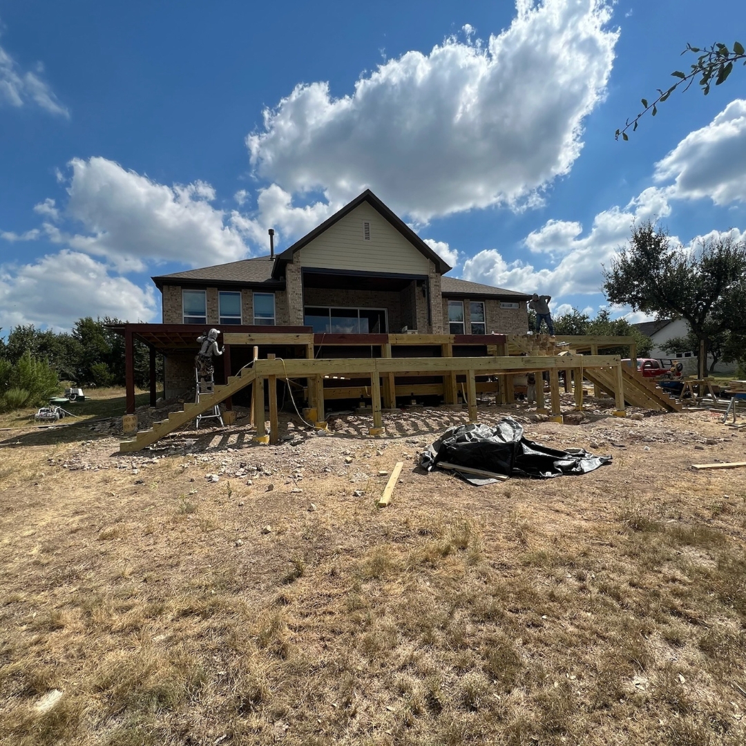 Progress view of deck project with materials, tools, and landscape lighting installation underway