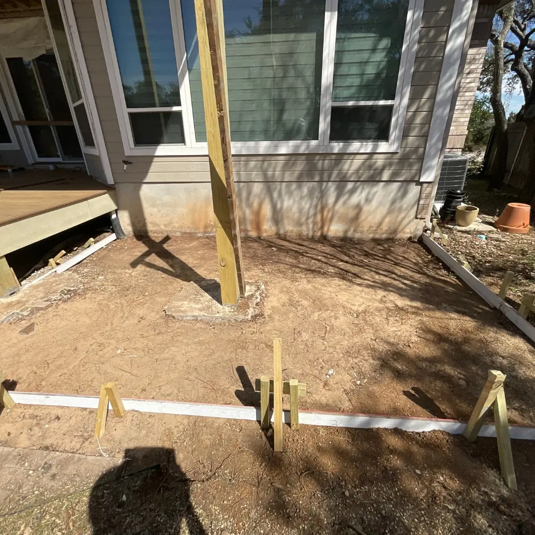 Project mid-build showing integration of multiple elements: deck framing, skirting, and outdoor kitchen base