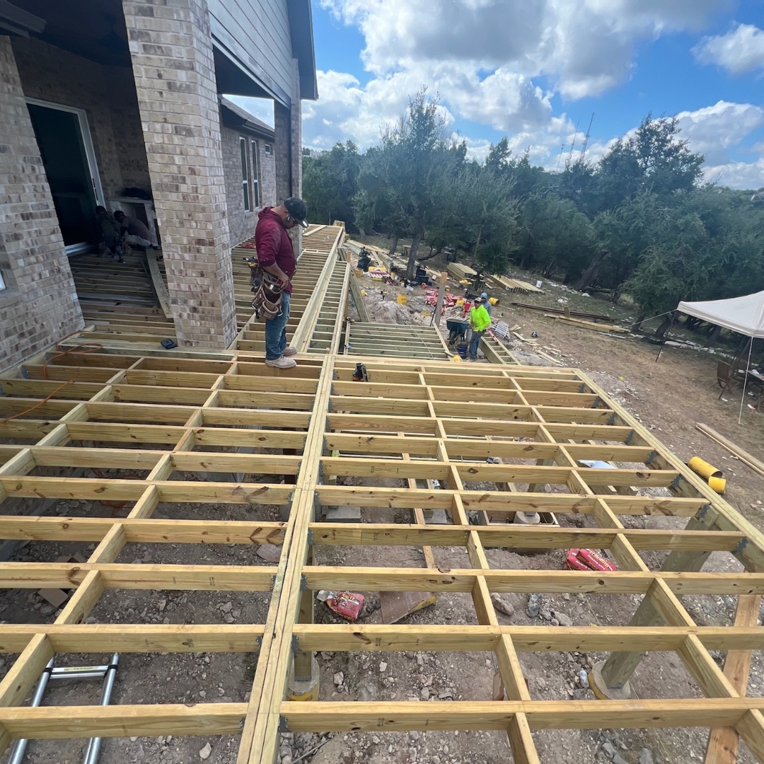 Workers installing Trex composite boards and preparing stainless steel cable railing system