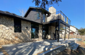 WUI-compliant TimberTech French White Oak deck with metal balustrade railing, metal soffit ceiling, and Hardie-wrapped gutter system