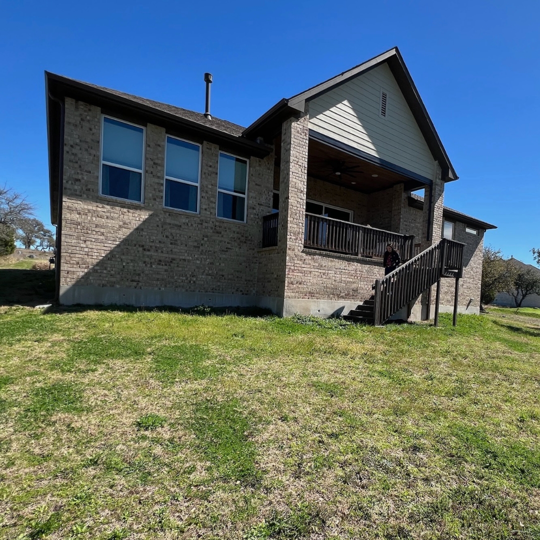 Exterior view of home with empty yard before adding deck, cover, and lighting