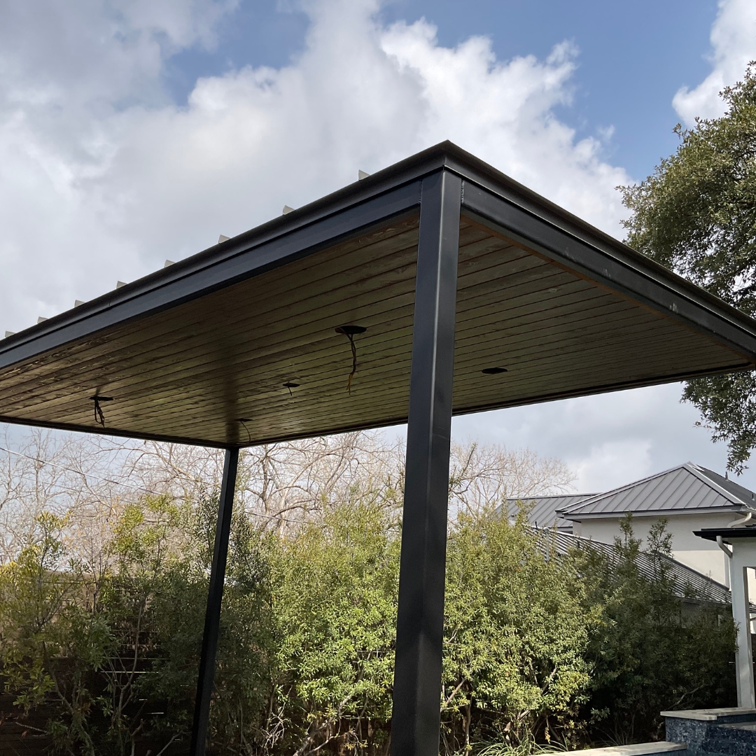 Construction of Mild steel patio cover with stained cedar soffit and Tricorn Black DTM paint finish