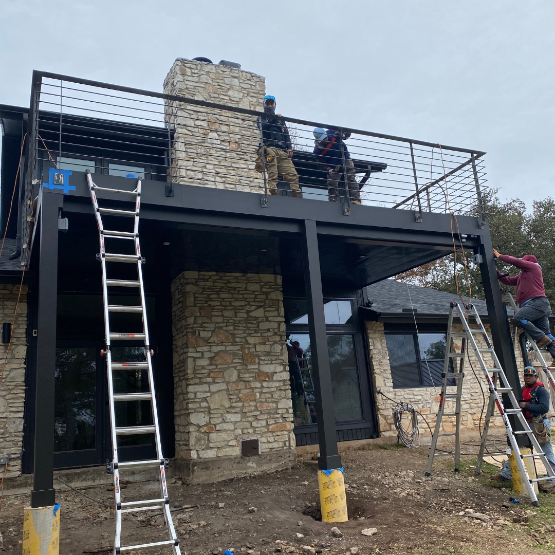 Mid-build view showing deck structure, metal balustrade posts, and soffit preparation