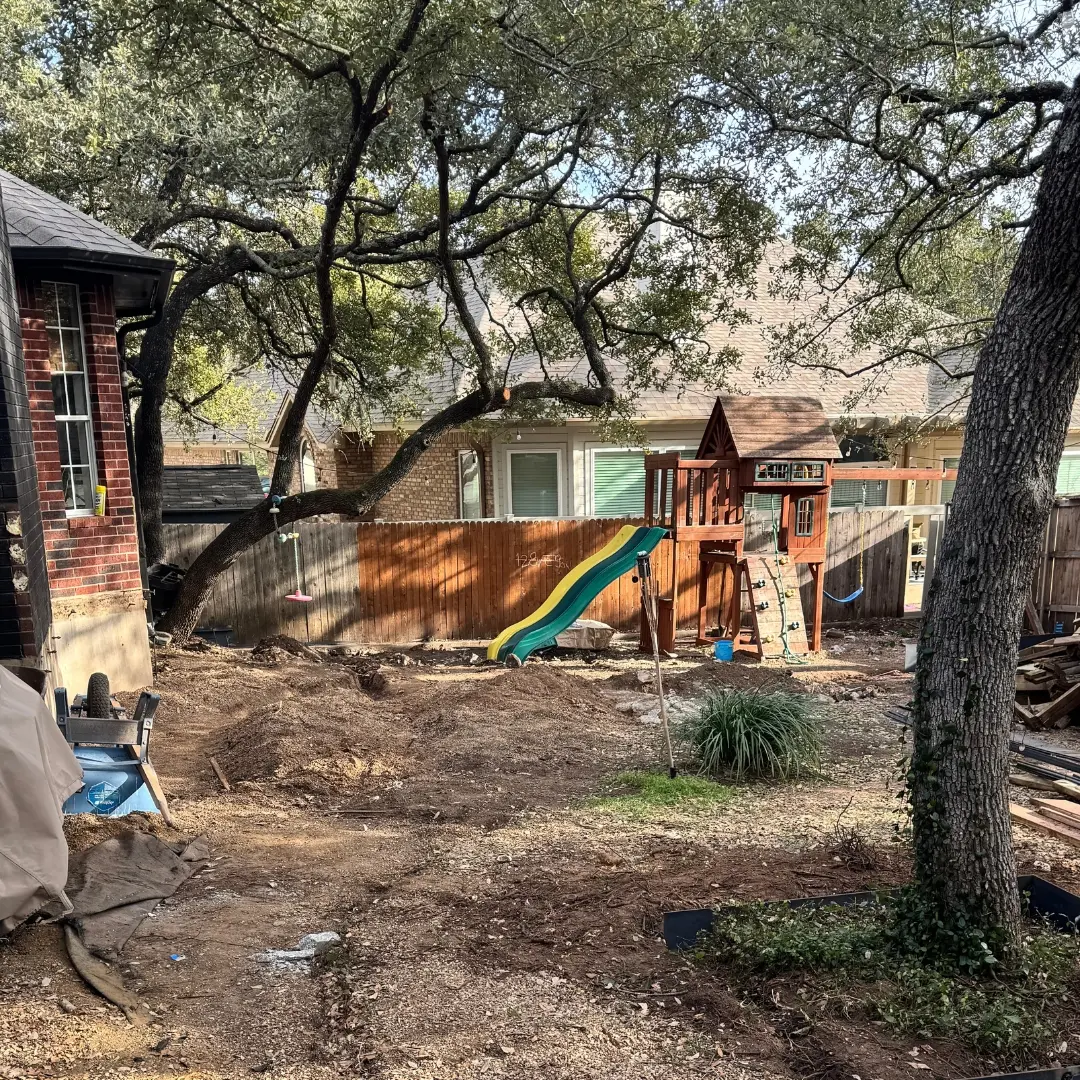 Unfinished yard before artificial turf and hardwood deck were added.