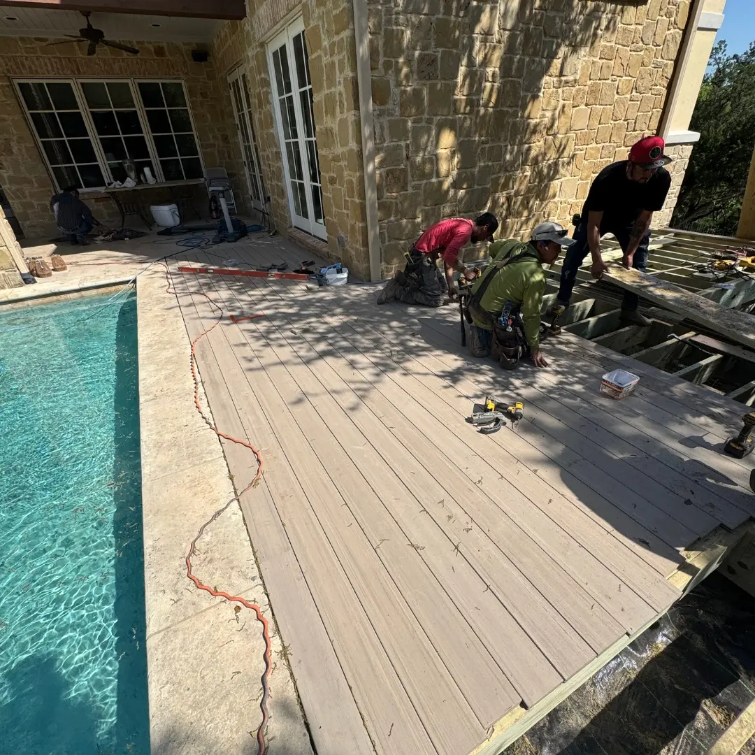 Workers securing starter boards along the house-facing edge of the deck