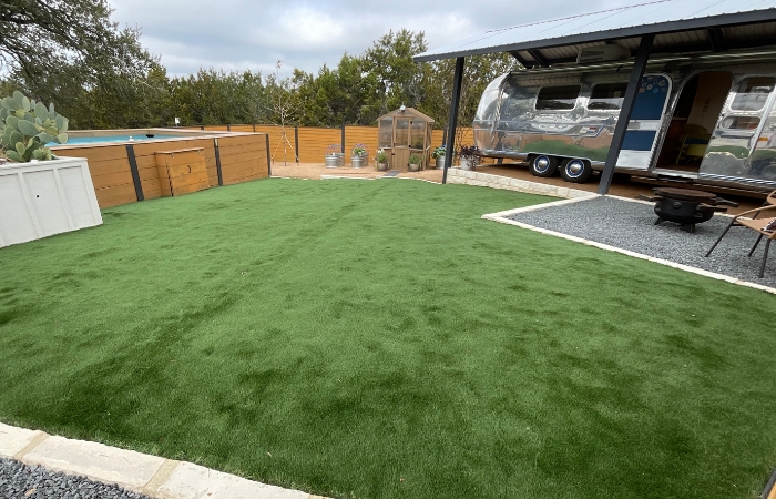 Wide view of the completed turf installation, blending seamlessly with the yard’s contours.