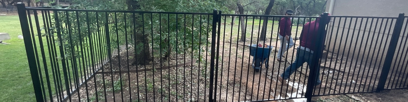 Newly installed ornamental iron fence with flat top and flat bottom style.