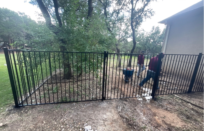 Newly installed ornamental iron fence with flat top and flat bottom style.