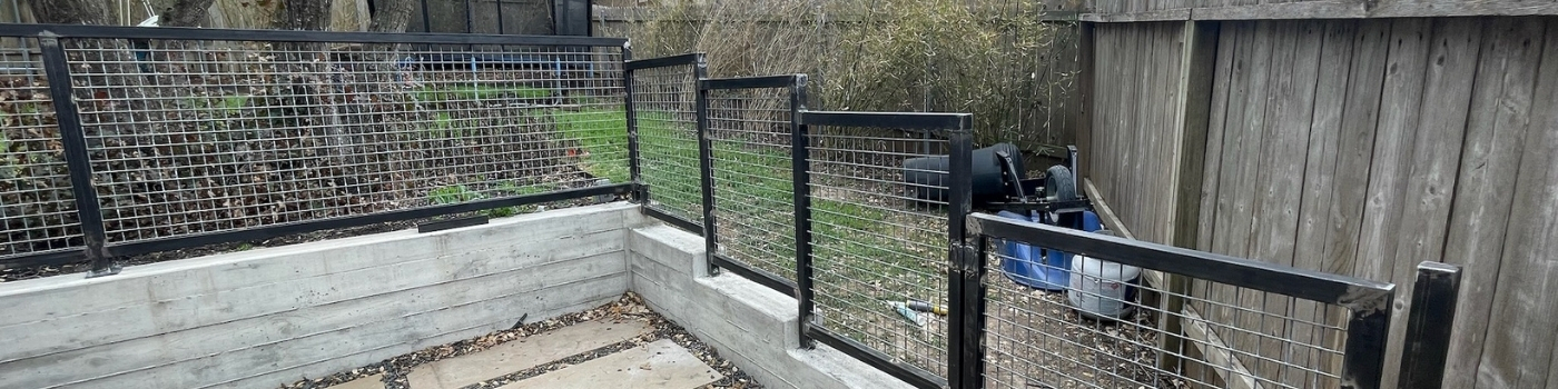 Installed bull panel railing with welded steel frame, mounted securely on a concrete wall.