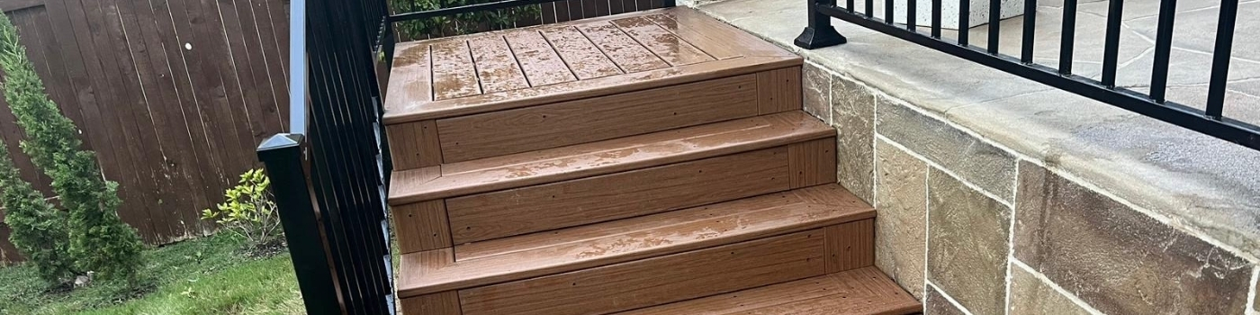 Completed Trex Okcracoke staircase with sleek ornamental iron railing.