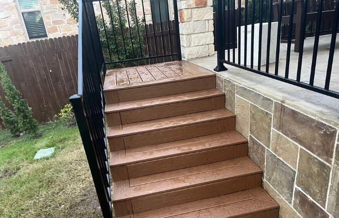 Angled view showing finished staircase connected to the deck with clean lines and durable materials.