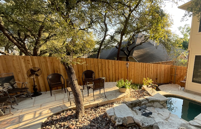 Backyard enclosed with fresh cedar fencing and sturdy metal supports.