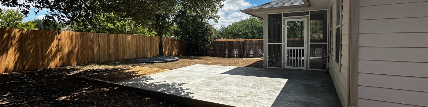 Wide view showing all outdoor features: concrete pad, hot tub area, and fire pit zone.