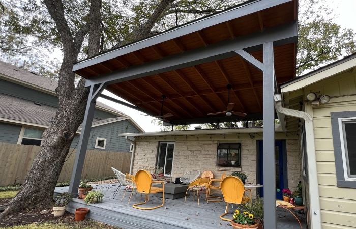 Completed patio cover with exposed rafters and T1-11 ceiling, providing shade over the new deck.