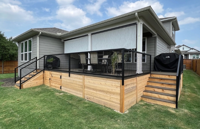 Modern deck area featuring composite decking, steel railing, and integrated shades.