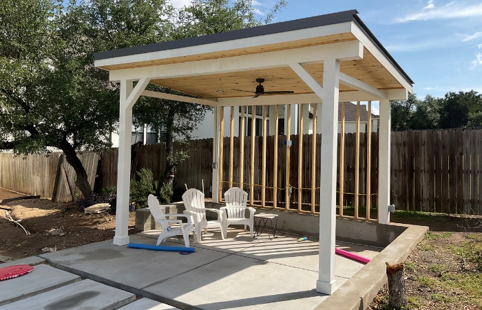 Finished single-pitch patio cover with standing seam metal roof and pine tongue-and-groove soffit.