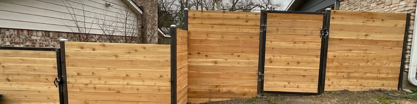 Horizontal cedar fence with steel posts installed around a residential backyard.