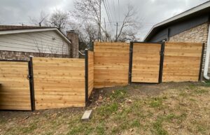 Horizontal cedar fence with steel posts installed around a residential backyard.
